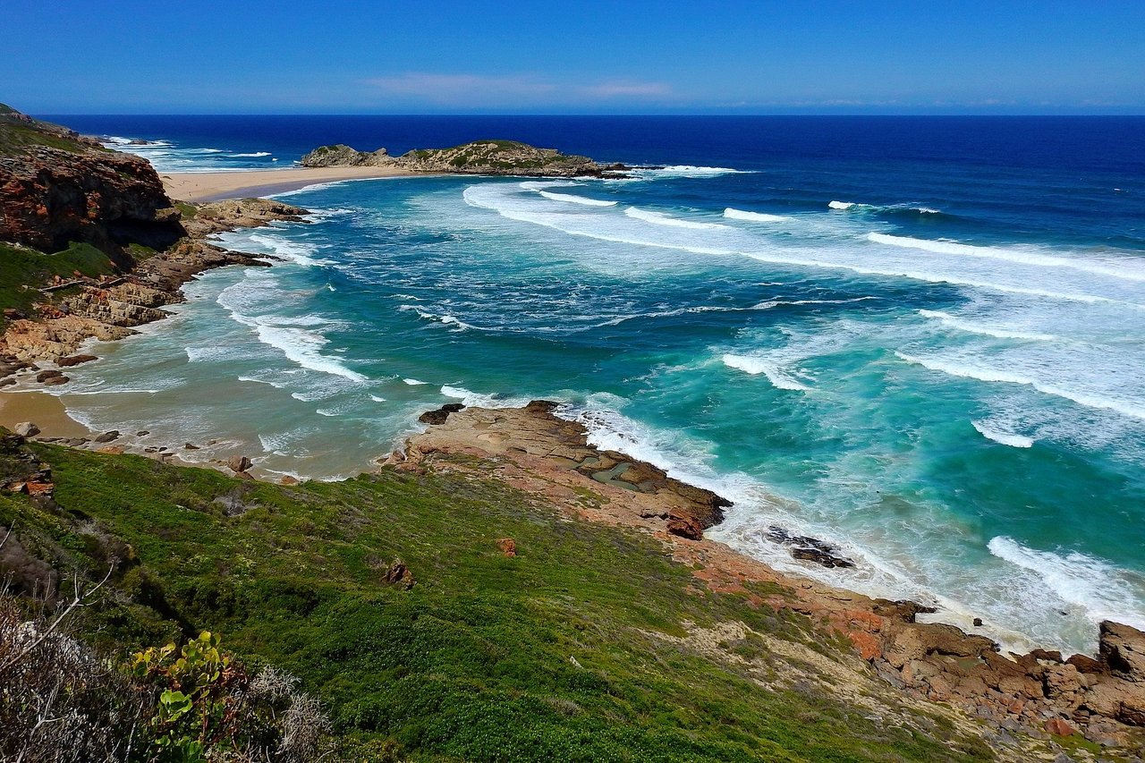 The Robberg coastline near Plettenberg Bay, turquoise surf breaking below fynbos cliffs