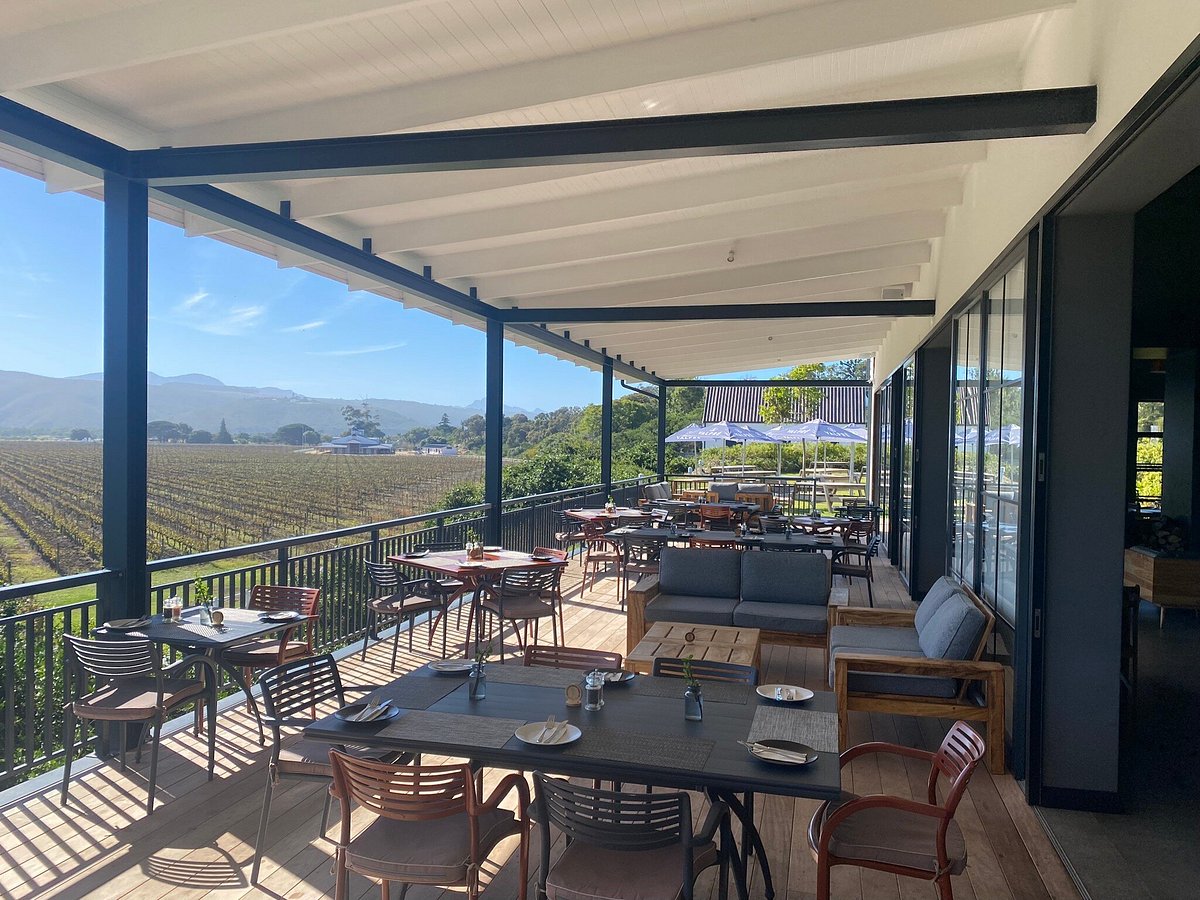 Covered terrace tables at Bitou Vineyards looking over the vines