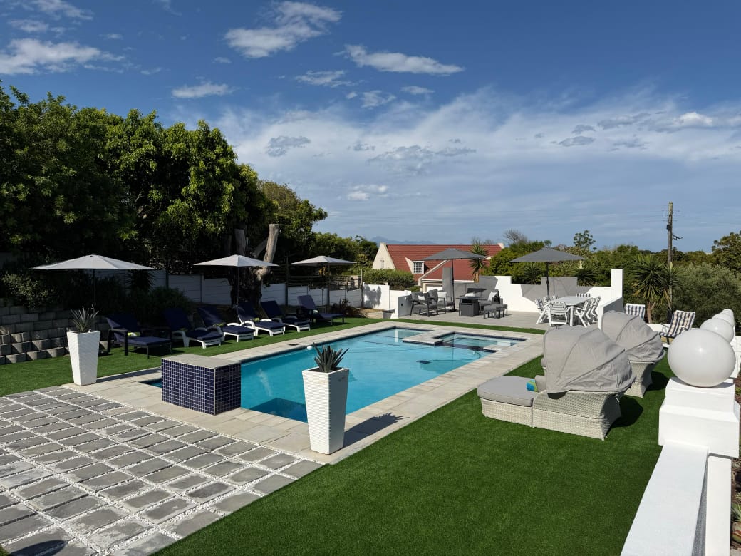 The Oasis pool terrace with sun loungers, umbrellas, and views across Plettenberg Bay