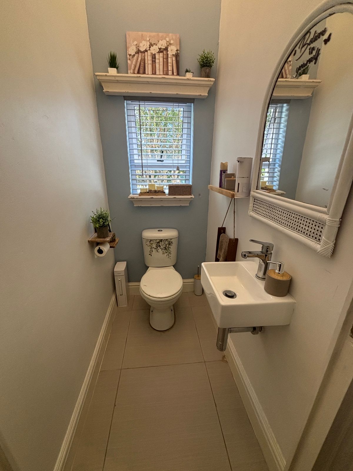 Separate guest bathroom with toilet, basin and mirror