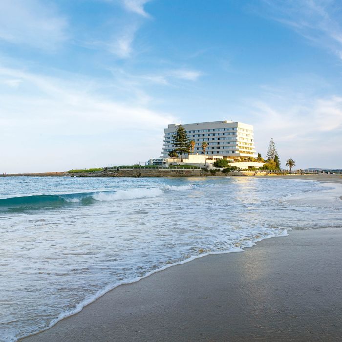 Surf rolling onto Plettenberg Bay main beach with the Beacon Isle hotel on the point