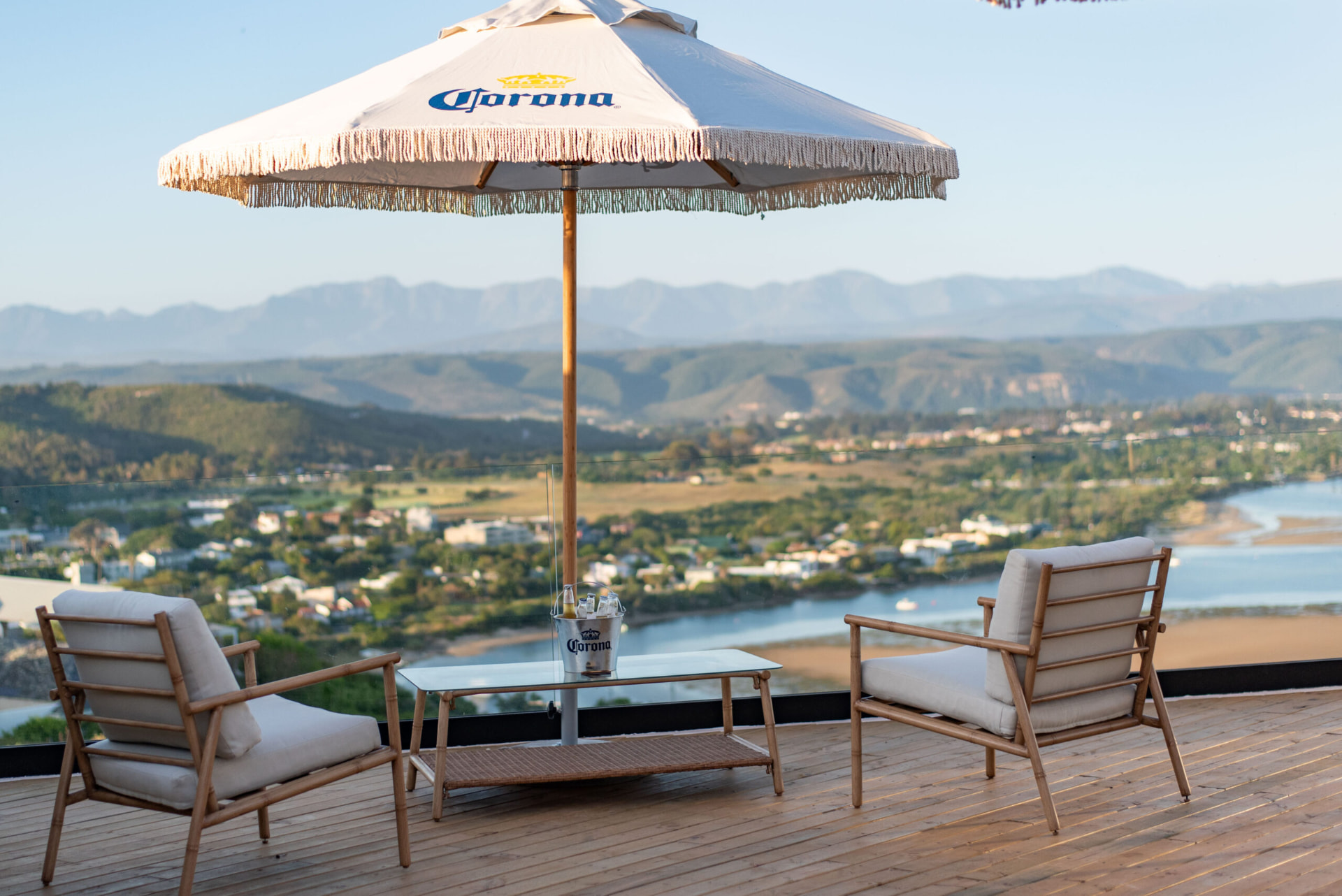 Terrace at The Palms with deck chairs and an umbrella overlooking the lagoon and mountains