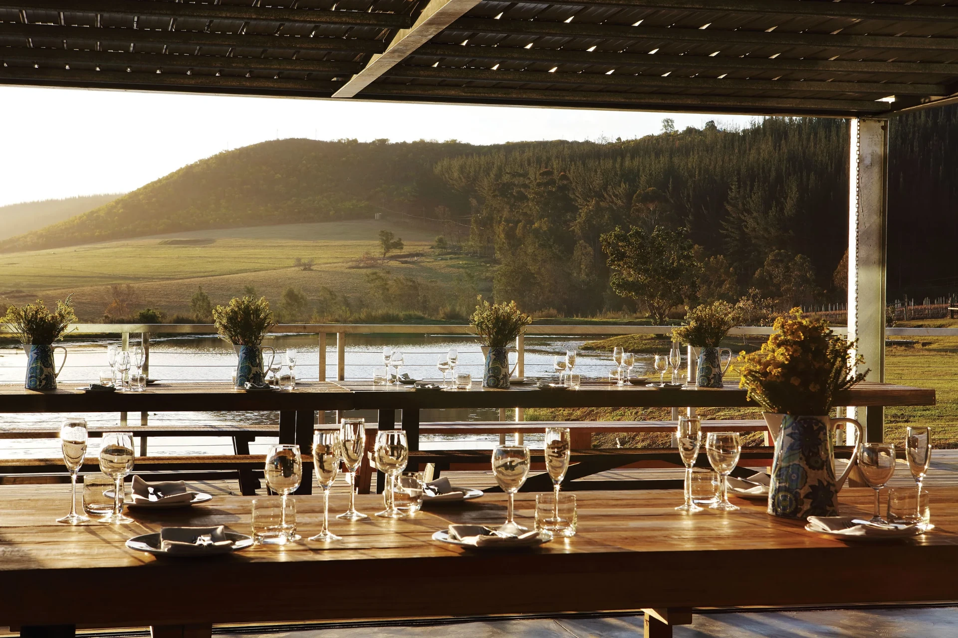 Long tables set under an open pavilion above the dam at Kay & Monty Vineyards